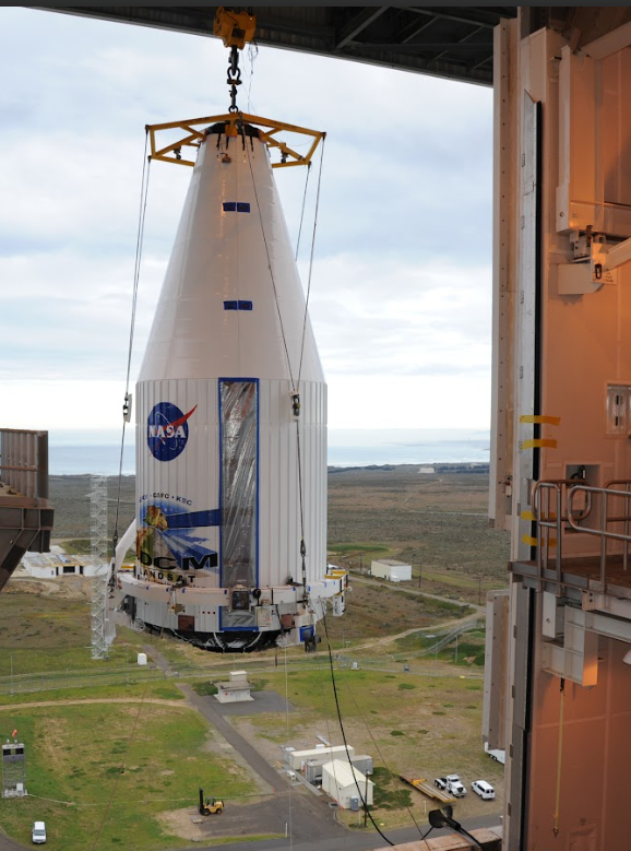 NASA rocket being lifted by a crane with a clear sky in the background