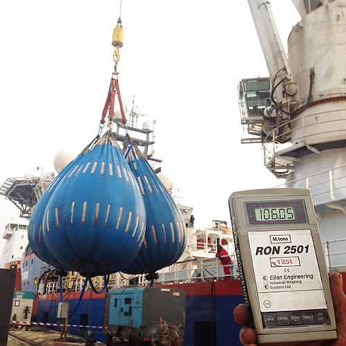 Three water bags are suspended from ship's crane